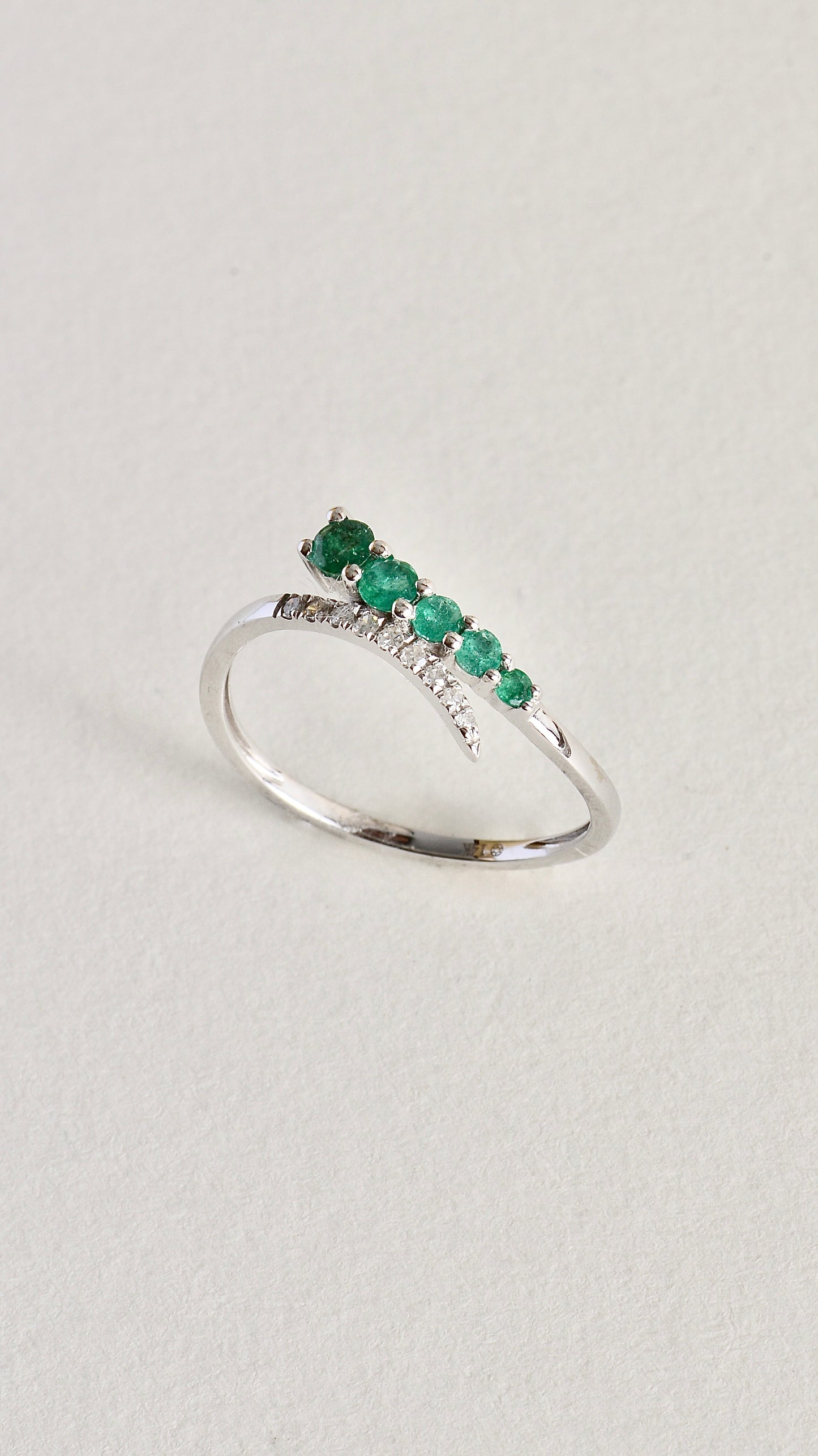 Anillo en oro blanco con diamantes y esmeraldas naturales