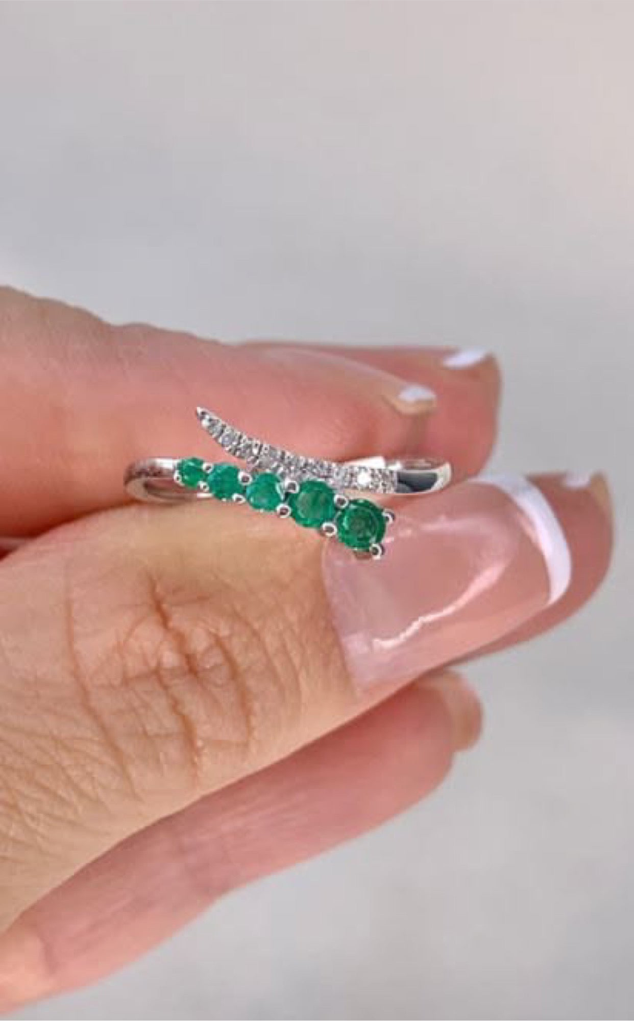 Anillo en oro blanco con diamantes y esmeraldas naturales